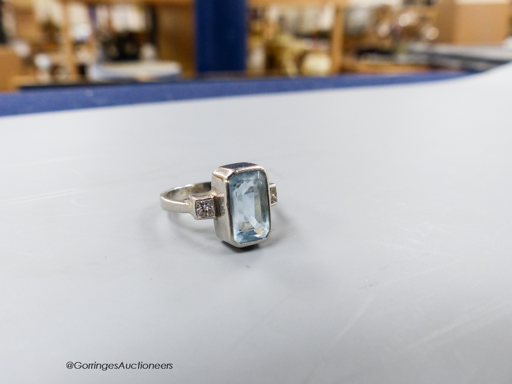 A modern platinum, aquamarine and diamond set three stone dress ring, size N, gross weight 6.8 grams.